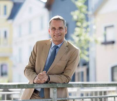 Kurdirektor Thomas Jahn lehnt an einem Brückengeländer in der Aiblinger Innenstadt.