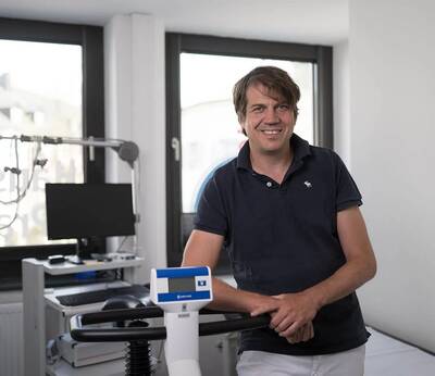Dr. Robert Hergenröther steht in seiner Praxis neben medizinischem Equipment.