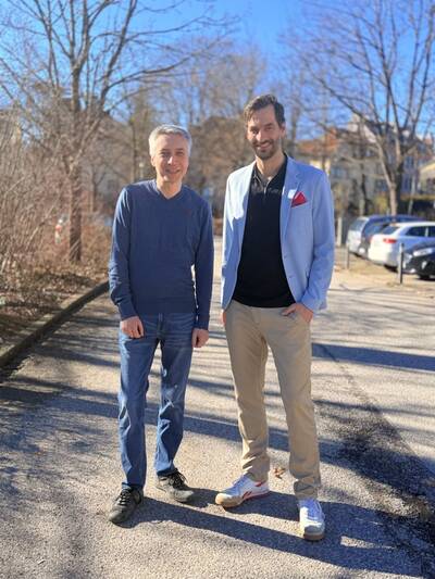 Robert Siersch und Podcast-Moderator Johann Struck  stehen auf einem gepflasterten Weg in einer sonnigen, städtischen Umgebung